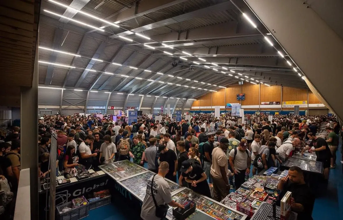 Een volle sporthal tijdens een Cardview beurs, met honderden bezoekers tussen de stands