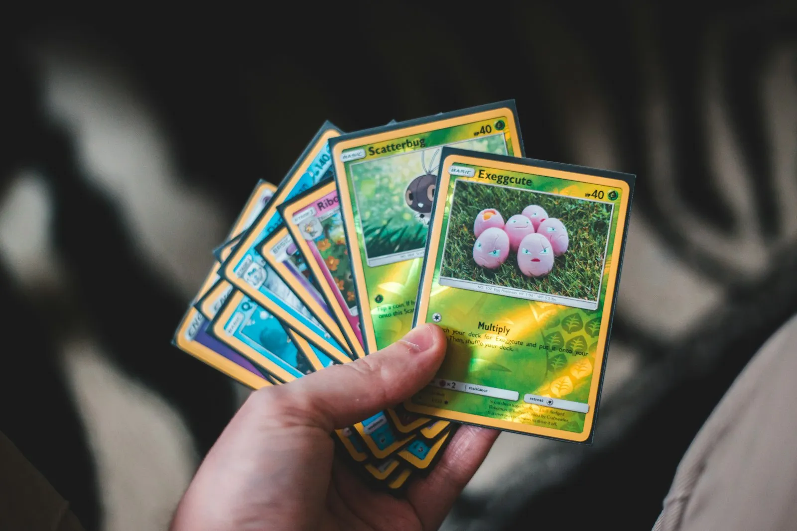 Een hand met een waaier Pokémon-kaarten